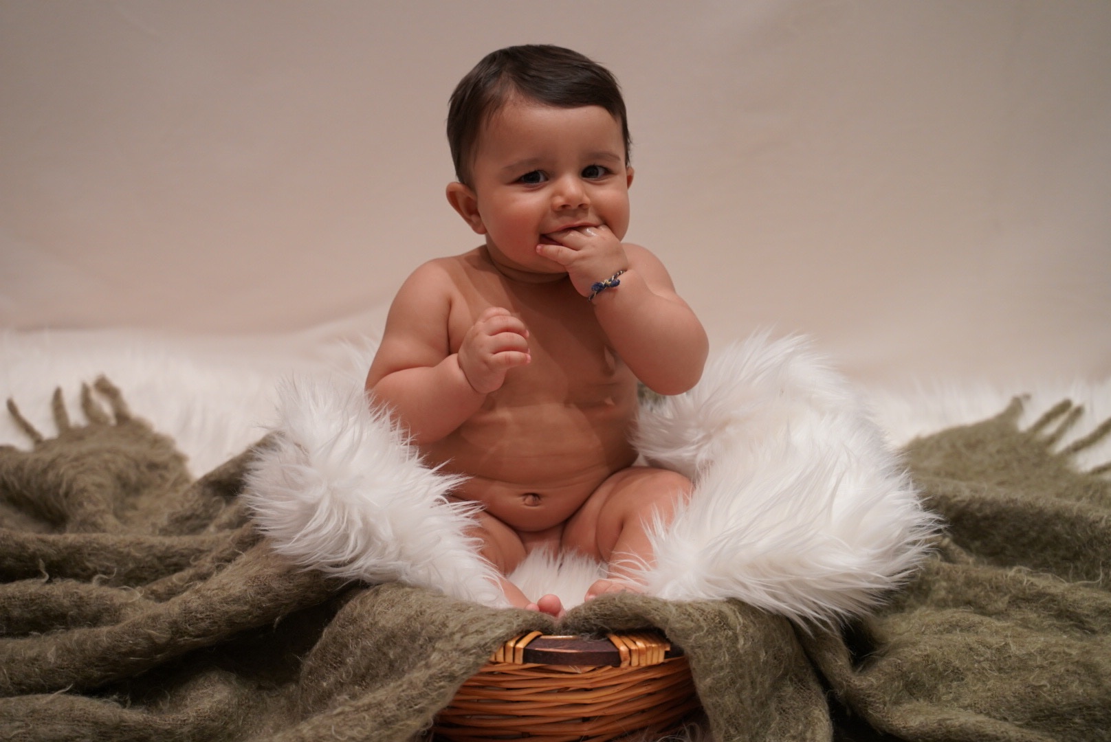 Smiling baby portrait with layered blankets in the studio
