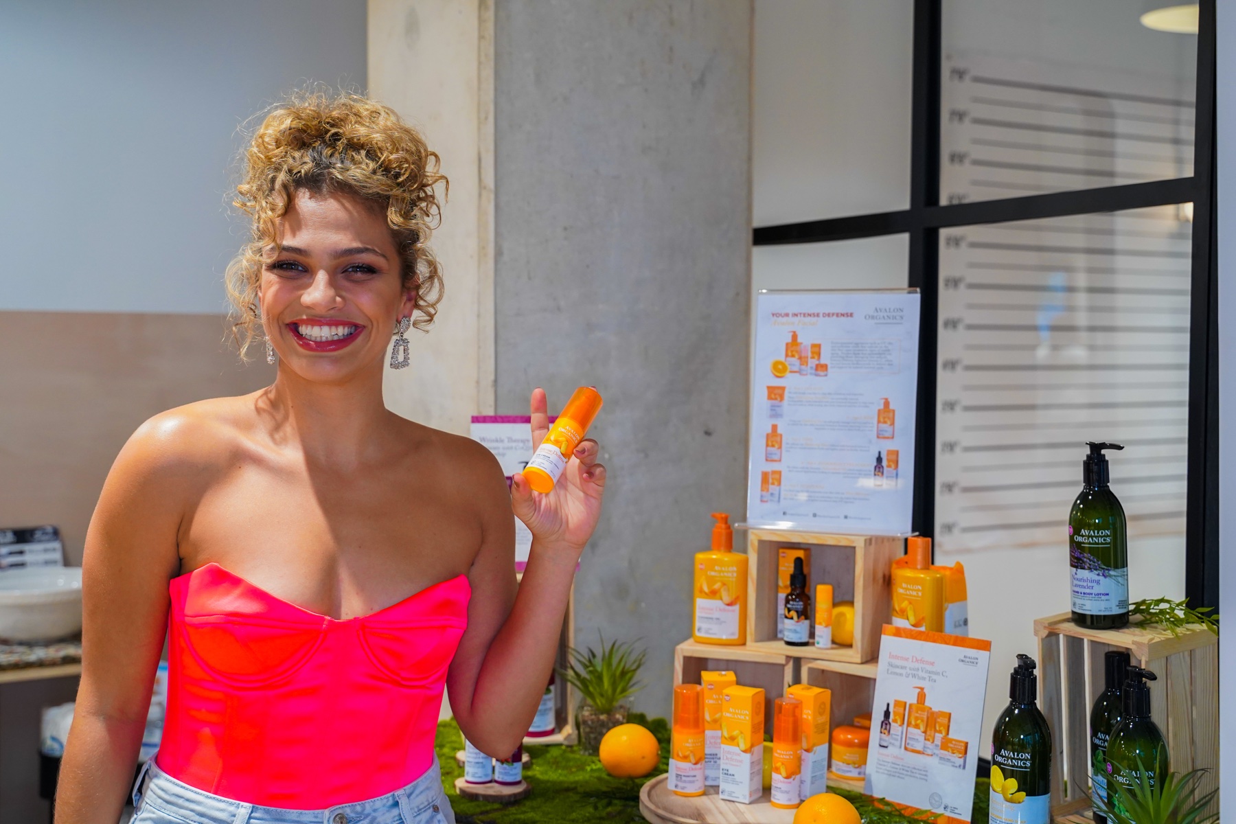 Skincare brand representative holding a product beside a display