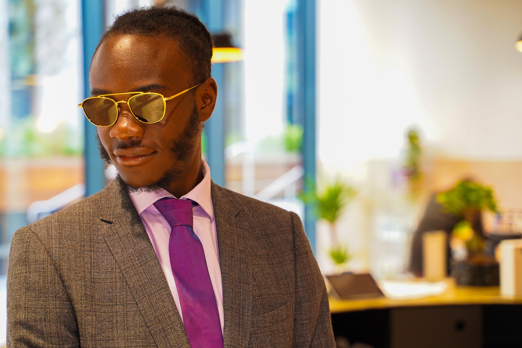 Man modelling gold-framed sunglasses at a brand event