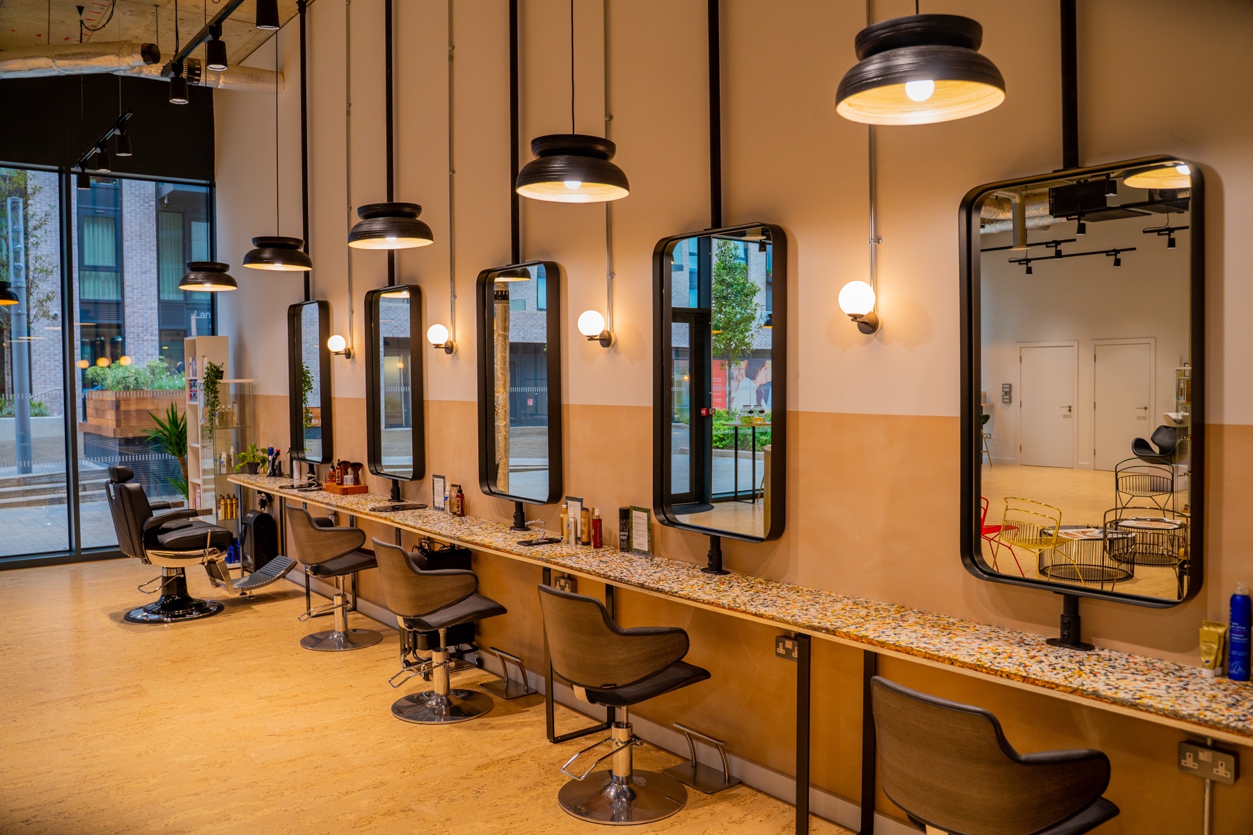 Commercial interior with a long row of mirrors and workstations
